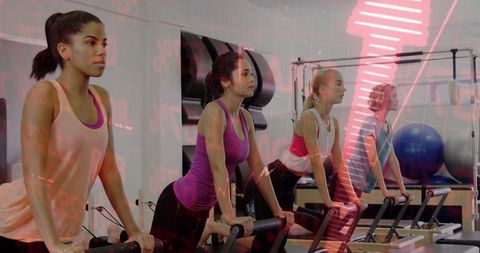 Women Practicing Pilates with Visual Data Overlay in Modern Gym