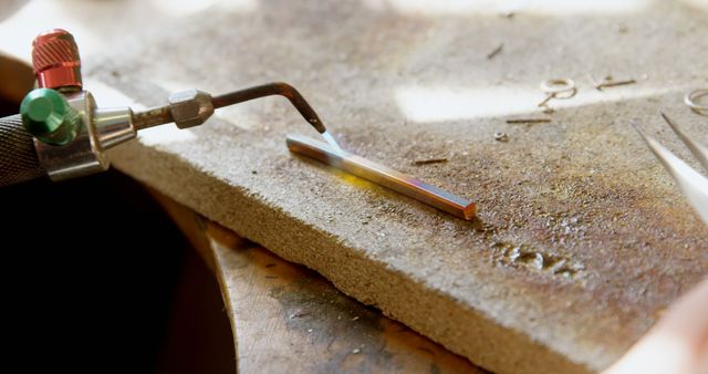 Close-up view depicting the deliberate process of soldering metal in a workshop environment. Fits well with content focused on trades, craftsmanship, and instructional materials on metalworking or DIY projects.