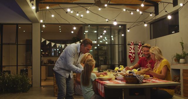 Family Relaxing Together Outdoors Having Dinner at Trendy Patio with Hanging Lights - Download Free Stock Images Pikwizard.com