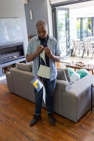 Smiling Man Arranging Banner Decorations in Modern Living Room