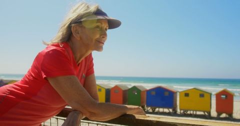 Active senior woman smiling seaside colorful beach houses