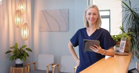Female Technician at Medical Clinic Reception with Tablet