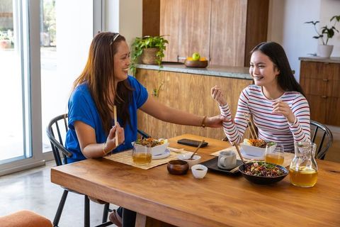 Asian Mother and Daughter Enjoying Meal and Bonding in Kitchen