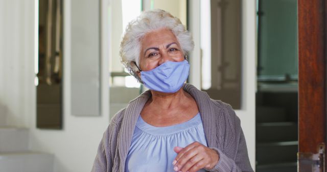 A masked senior African American woman opens her door, embodying a quarantined retirement life. - Download Free Stock Photos Pikwizard.com