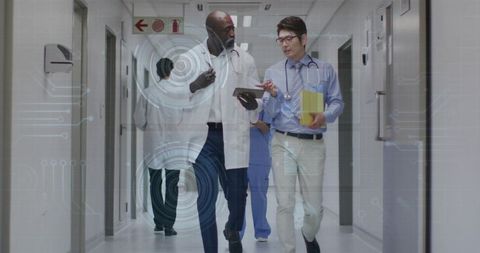 Doctors walking hospital corridor reviewing patient data on tablet with ar overlay