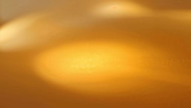 Golden halo abstract background glowing oval light emitting warm amber macro soft texture