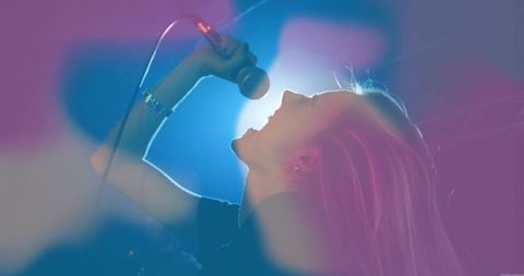 Dynamic Solo Female Singer Performing on Stage with Vibrant Haze