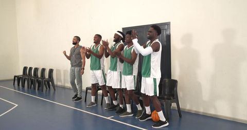 Basketball Team Celebrating Coach's Strategy Success on Court