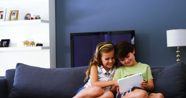 Happy Children Sitting on Couch Using Tablet in Living Room - Download Free Stock Images Pikwizard.com