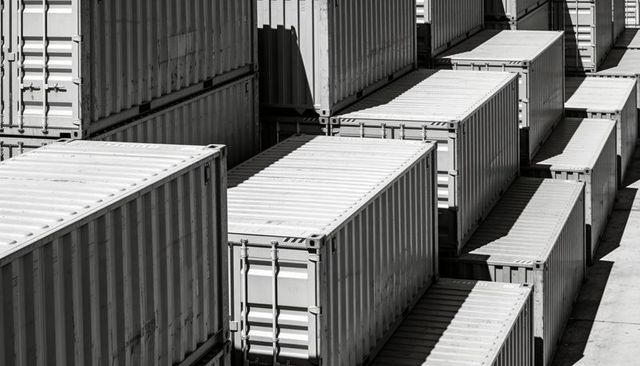 Stacked cargo containers creating parallel rows at freight terminal monochrome industrial geometry