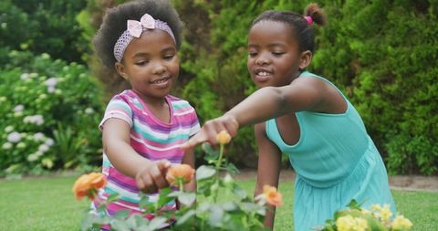 Joyful African American Girls Gardening with Yellow Flowers