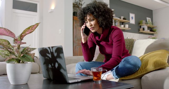 Young Woman Working on Laptop While Talking on Phone from Home - Download Free Stock Images Pikwizard.com