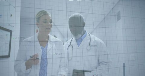 Doctors Analyzing Data on Tablet in Modern Hospital Corridor