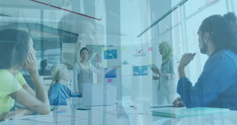 Creative Team Meeting Analyzing Market Trends with Data Graphs