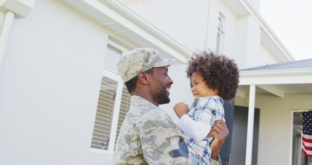 Image of biracial son welcoming african american soldier father. American patriotism, armed forces and family life.