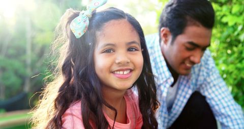 Happy Daughter Enjoying Gardening with Father Sunlit Outdoors