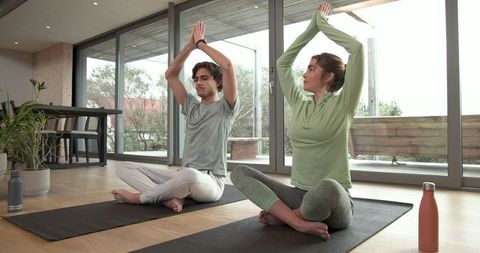 Couple practicing seated yoga at home for relaxation