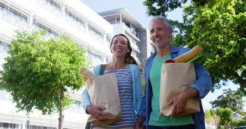 Mature Couple Enjoying a Sunny Day with Groceries
