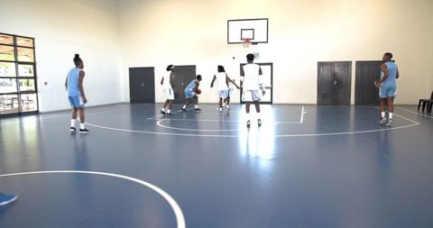 Athletic players competing basketball game indoor gym setting