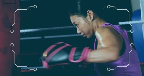 Female boxer training with intensity in boxing gym