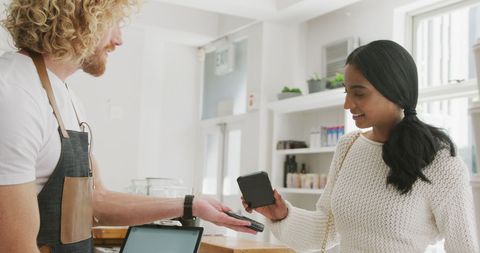 Customer making smartphone payment to barista in cozy cafe - Download Free Stock Images Pikwizard.com