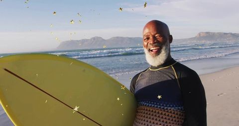 Cheerful Senior Surfer on Sunny Beach Holding Surfboard
