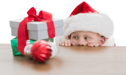 Curious Boy in Santa Hat Peeking at Christmas Gifts on Transparent Background