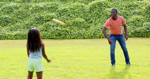 Father and daughter playing fetch with creative frisbee
