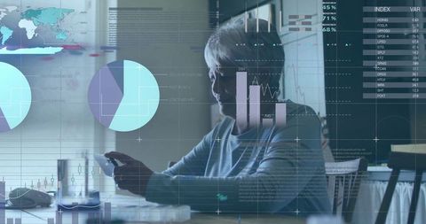 Senior woman using smartphone and computer mouse in modern workspace