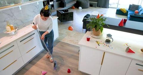 Elderly woman tidying up after a lively party celebration
