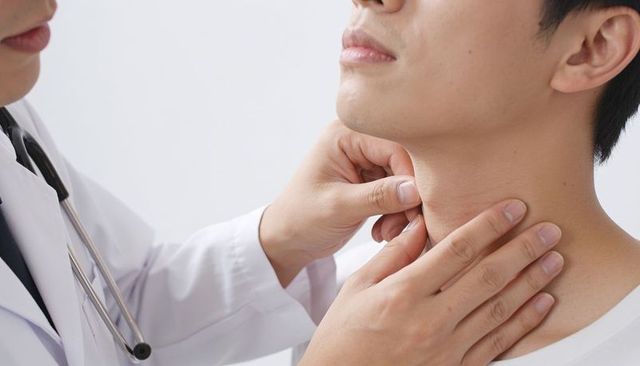 Doctor palpating neck during clinical throat examination close-up