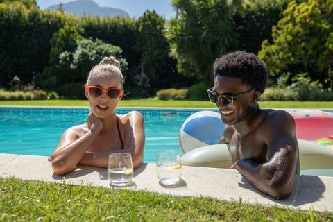 Couple Relaxing by Poolside on Sunny Day