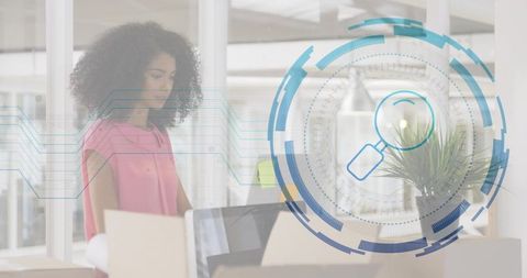 Woman organizing office boxes while using laptop with futuristic HUD analytics overlay