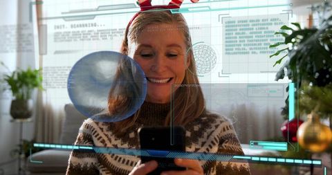 Smiling woman scrolling smartphone with festive augmented reality in cozy living room