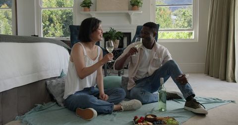 Couple Enjoying Wine and Relaxing Indoor Picnic