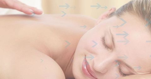 Relaxed woman receiving back massage with therapist hand and blue arrows for wellness