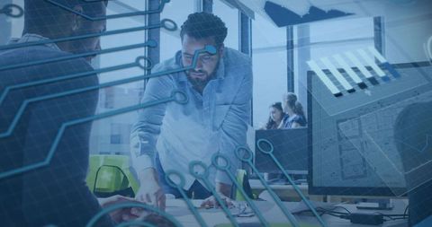 Engineering team collaborating over blueprints with circuit overlay in modern office