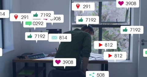 Remote worker leaning over desk surrounded by social media engagement notifications