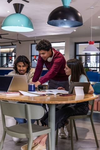 Young multicultural team collaborating around laptop in modern coworking space