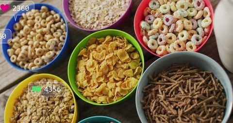 Colorful cereal bowls featuring variety of grains, flakes and loops on rustic wooden table