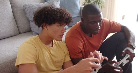 Diverse Male Friends Gaming Together in Living Room