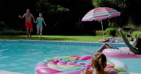 Diverse Friends Enjoying Poolside Fun with Colorful Floats