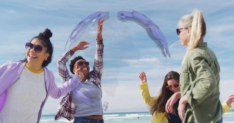 Friends laughing and reaching under holographic bubble on sunny beach summer vibe