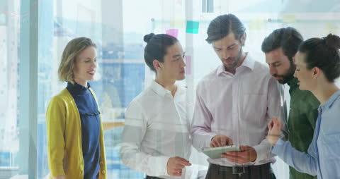 Diverse Business Team Discussing Data on Tablet in Modern Office