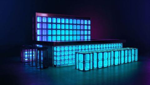 Glowing modular neon cube bar creating futuristic cyan-blue light installation for events