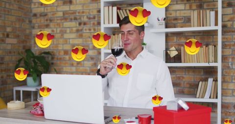 Man enjoying virtual wine date with love emojis
