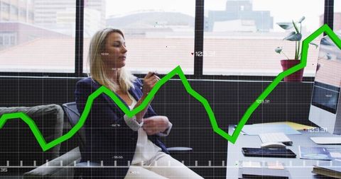 Female executive analyzing market performance on desktop with rising green line graph