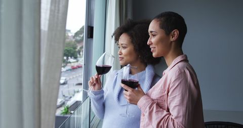 Diverse Lesbian Couple Relaxing at Home with Wine