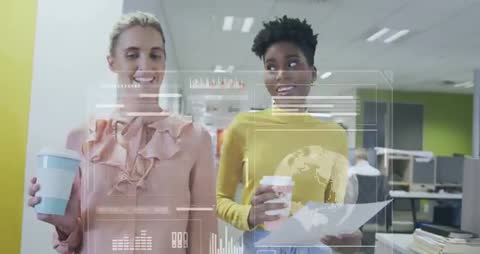 Two Women Holding Coffee While Engaging with Digital Data Graphics