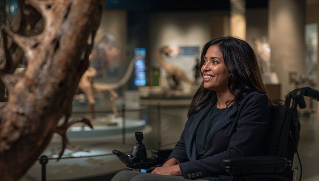 Woman in wheelchair engaging with exhibits in museum